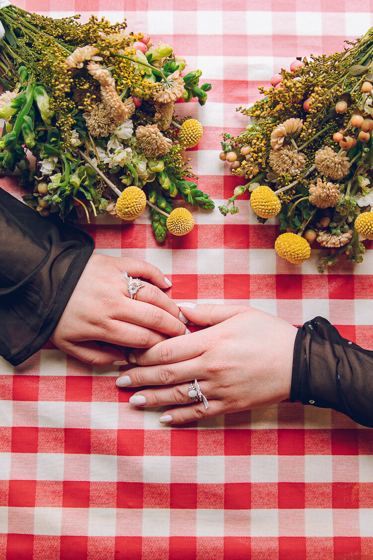 A queer couple holding hands at Portillo's in Chicago on their wedding day