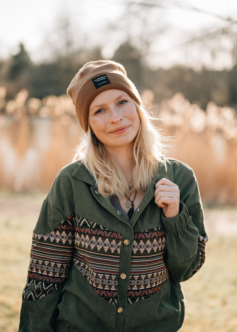 Blonde Frau mit Mütze in der Natur