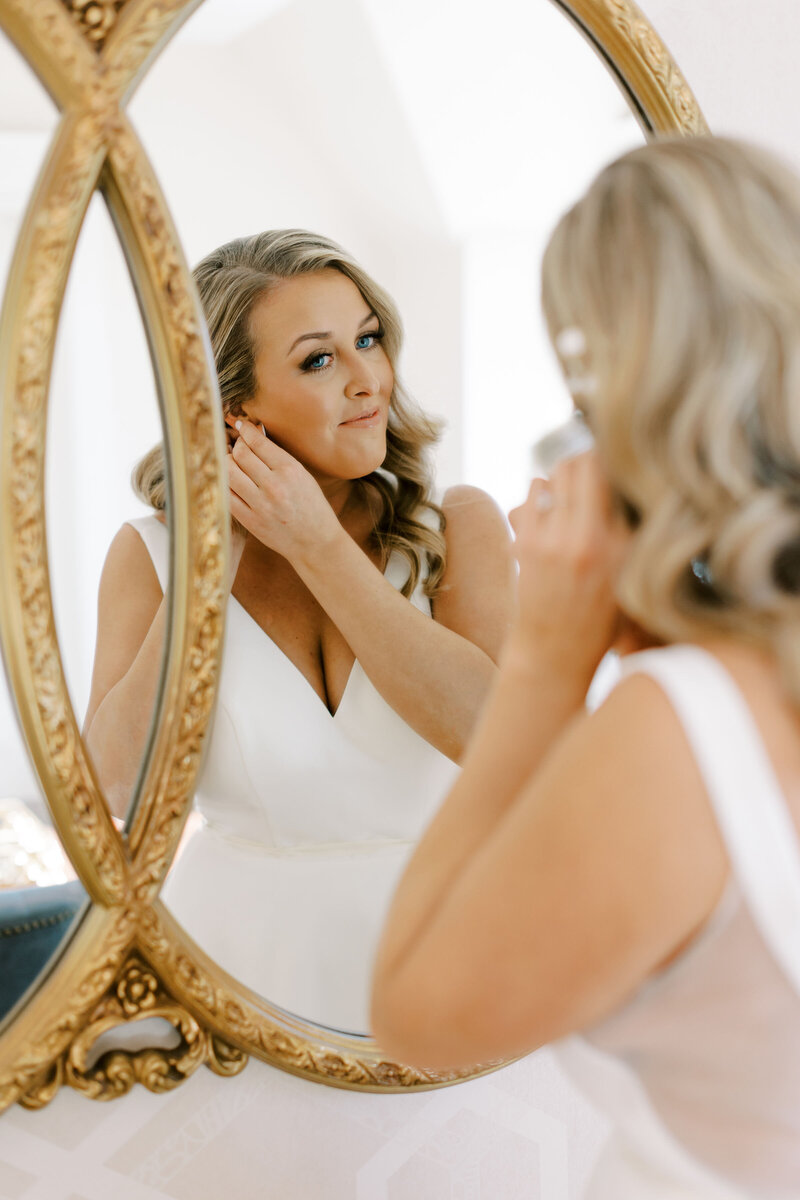 Bride puts her earring in photography by Cynthia Mae Grand Rapids Wedding Photographer