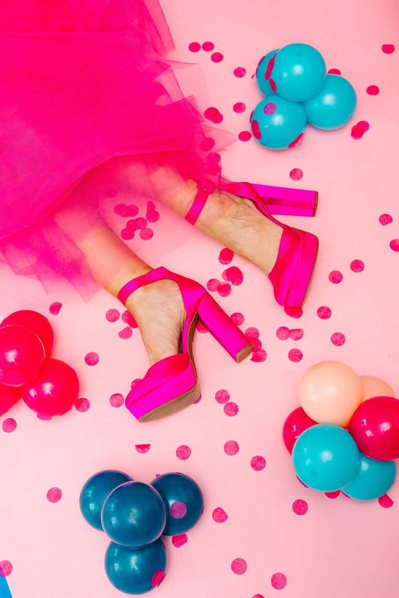 Raleigh Balloons, Event Decor and Rentals expert in a pink fun dress with Pantone accents presenting the balloon sizing guide and creative décor services
