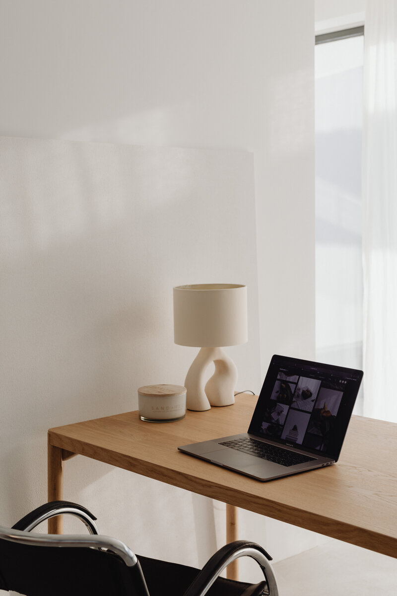 Wooden desk with laptop and chic black chair
