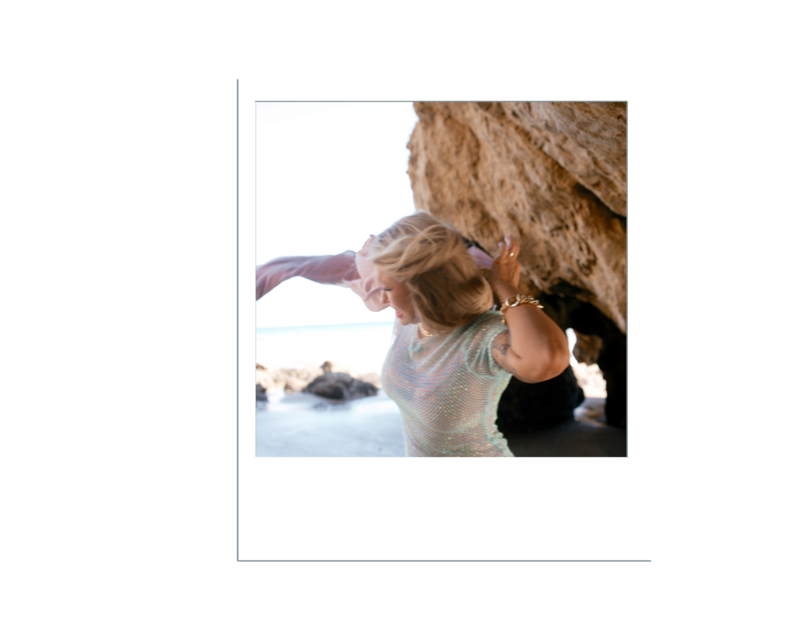 Nicky Lynn dancing on the shoreline in a blue dress, expressing freedom, joy, and emotional release
