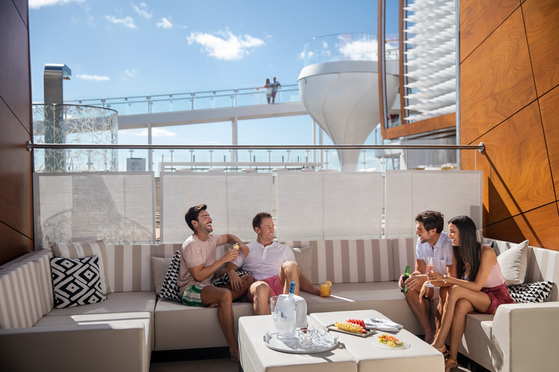 Several people gathered around a table on a cruise ship