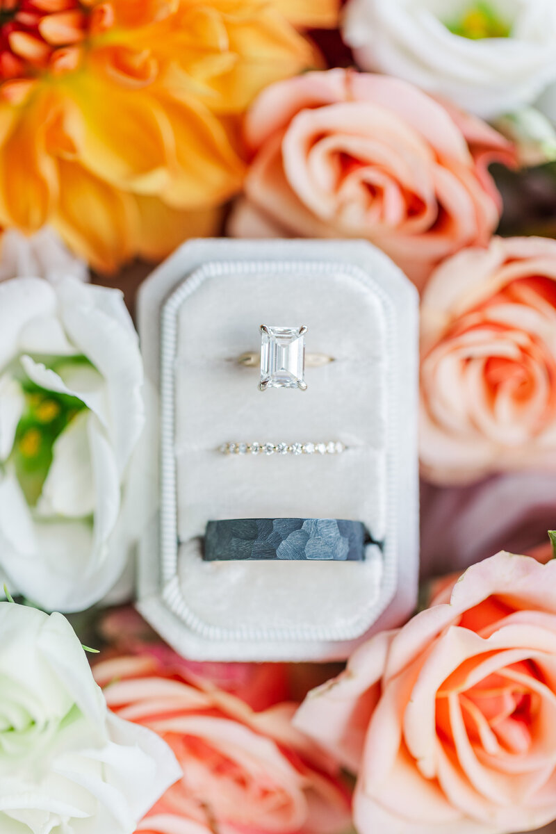 wedding rings in a ring box surrounded by flowers
