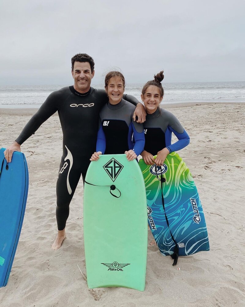 Brad surfing with two of his daughters