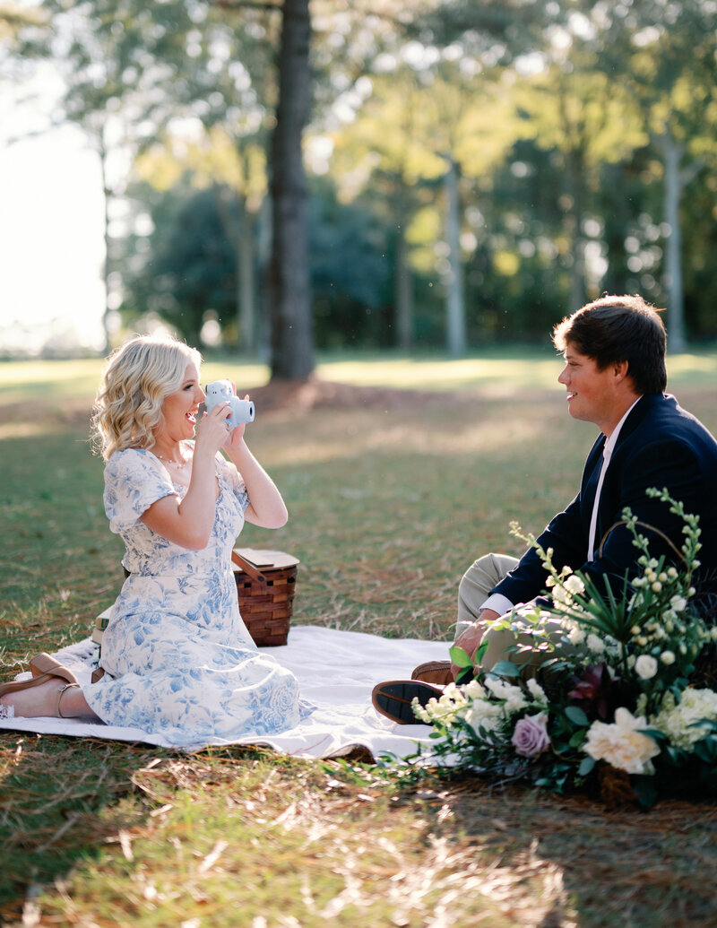 A couple poses during their engagement session in a lush, green garden.