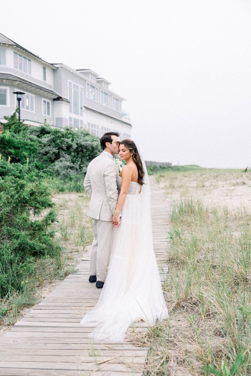 Romantic wedding portrait of couple walking through sand dunes in Cape Cod