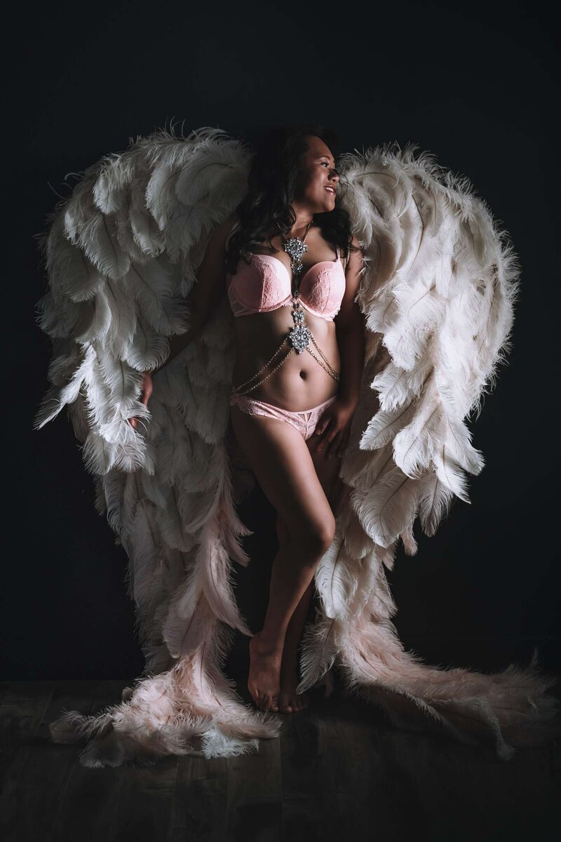 A boudoir photoshoot in Vancouver with angel wings looking away from the camera