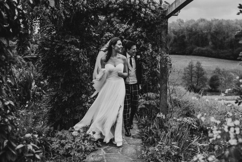 Black and white photo of bride and groom in garden