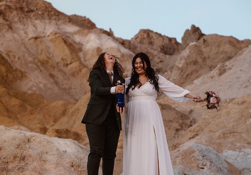 Couple overlooking canyon with backpacks that say "Just Married"