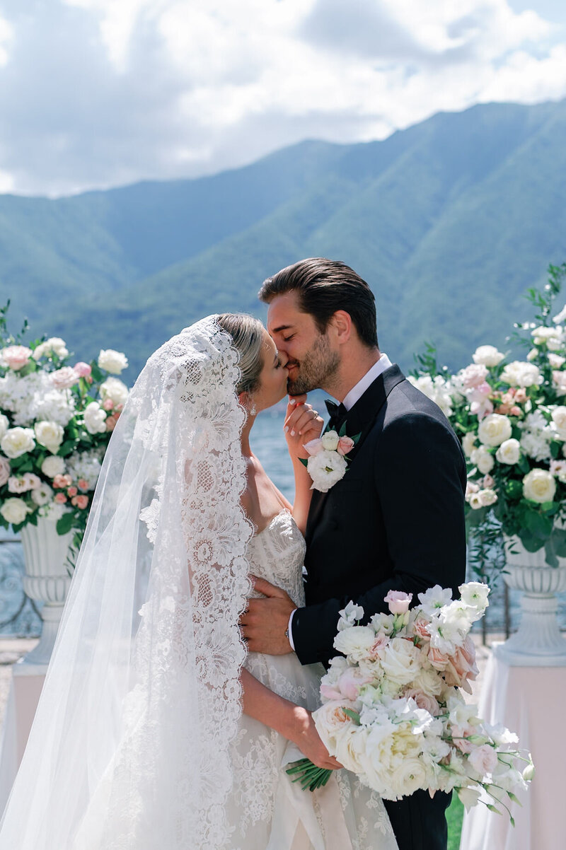 Bride in a flowing wedding gown standing by large windows, captured by a Virginia Wedding Photographer in a beautifully lit Estate at River Run in Maidens, Virginia