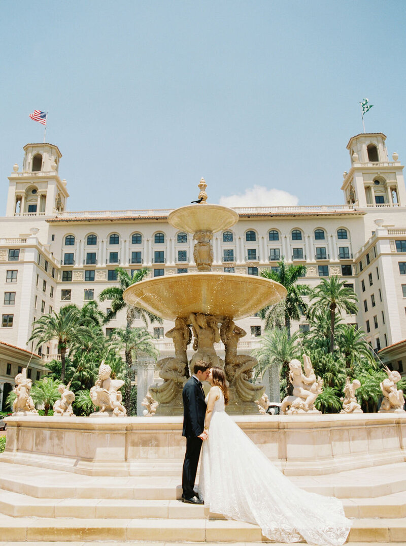 Bride and Groom kissing in front of fountain