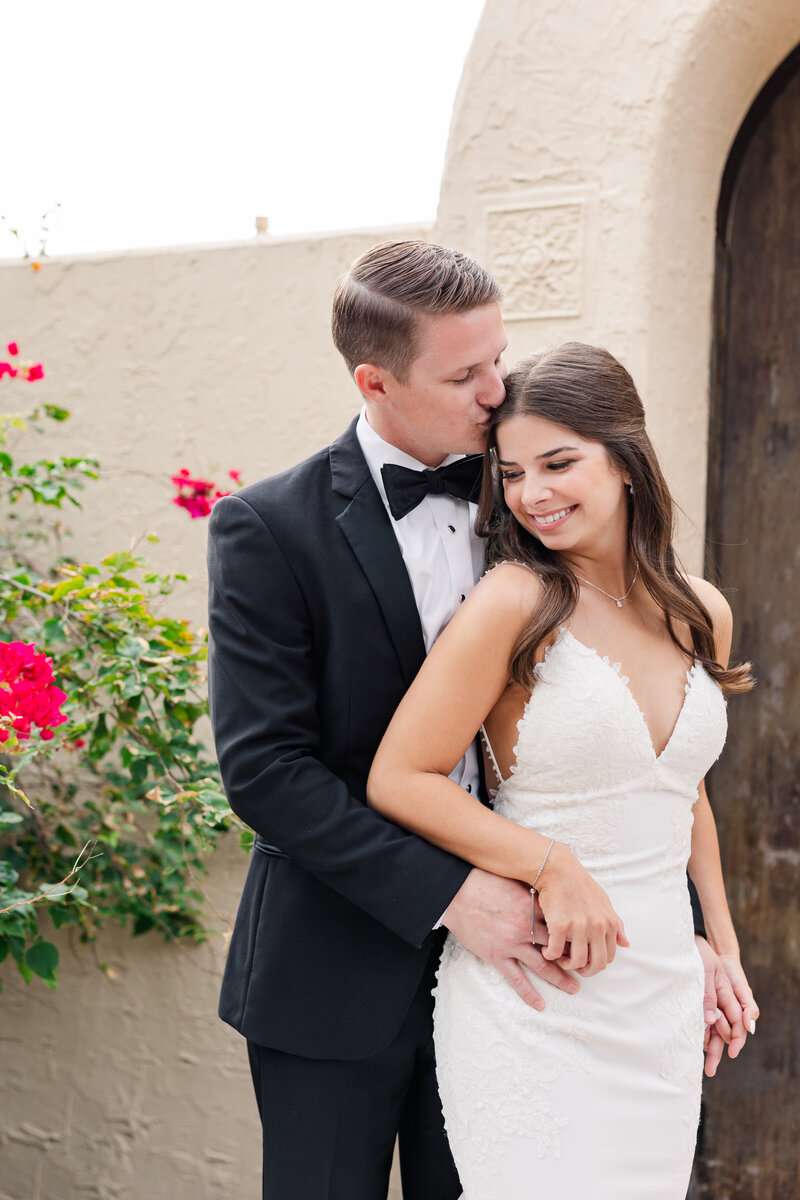 Bride twirls her dress while groom is smiling at her in front of romantically candlelit staircase at The Orlo