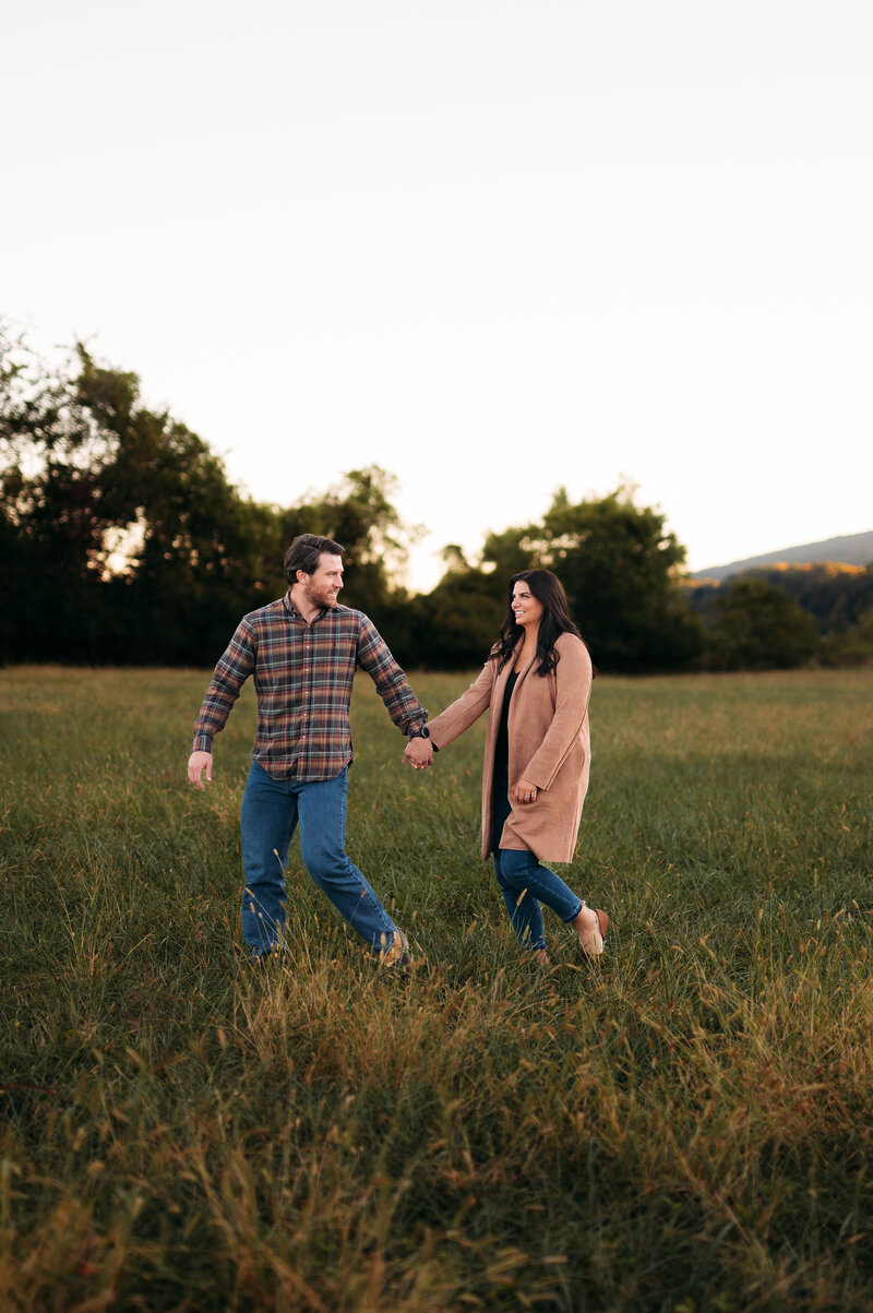 couple posed walking through open field in chattanooga tennessee