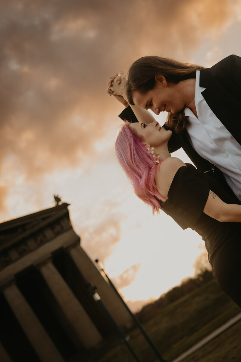 couple dancing in front of parthenon at sunset