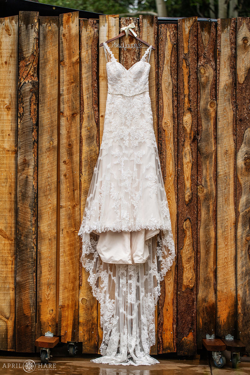 Wedding dress hanging on wood wall at Blackstone Rivers Ranch