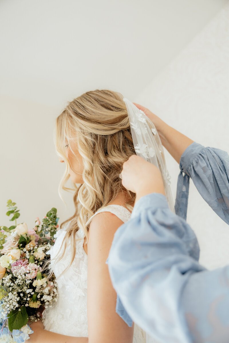 A groom kissing his bride's temple as she looks down.