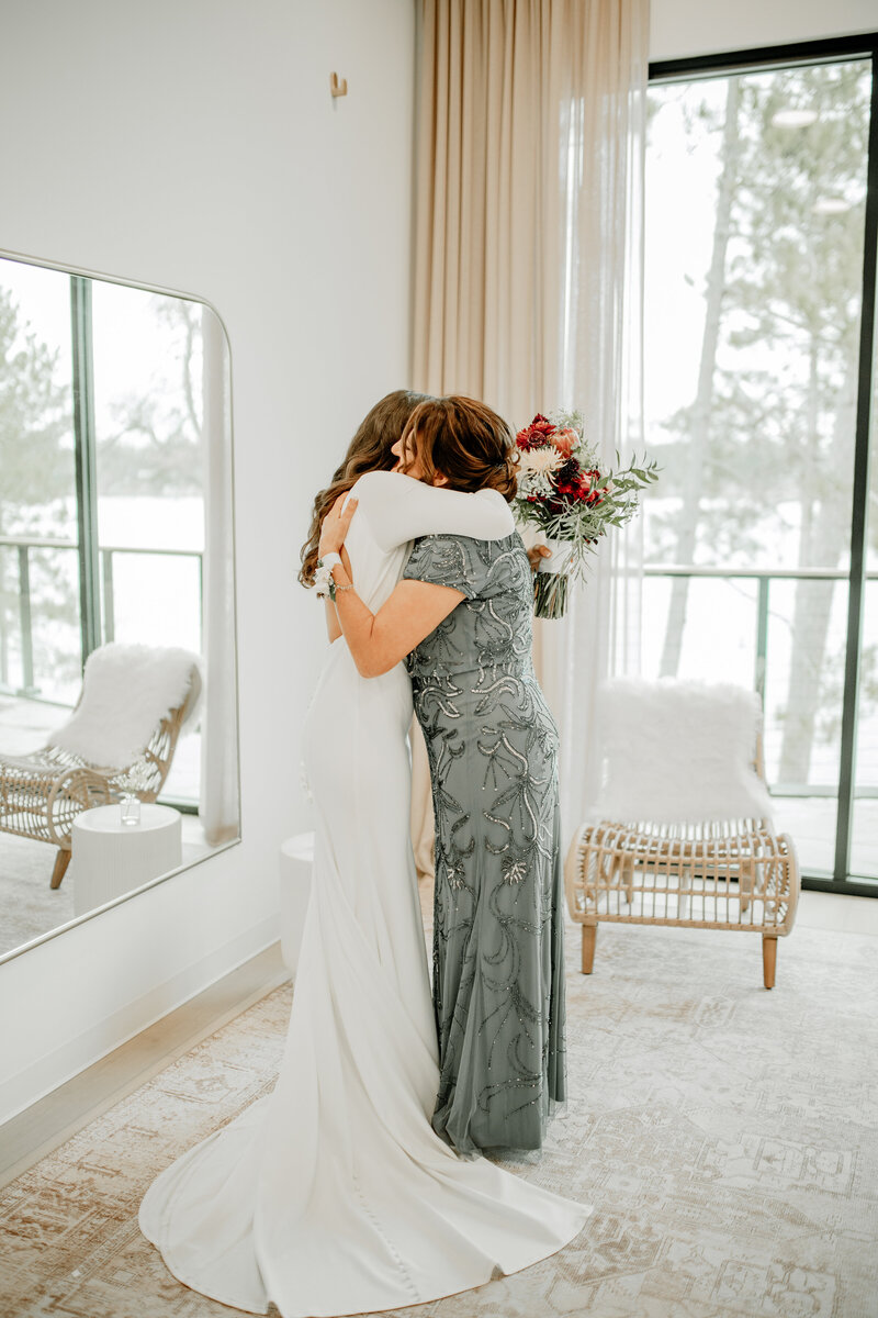A candid moment between the bride and her mother while getting ready photographed by Duluth photographer, Emmie Verdell.