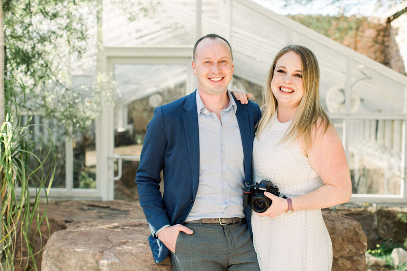 Morgan and Ryan smiling  and holding a camera, a Madison Wisconsin Wedding Photography duo