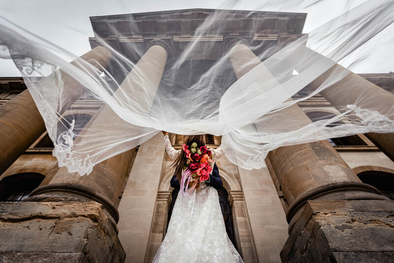 Bride and groom embrace in front of historic Yorkshire building - captured by Yorkshire wedding photographer and videographer.