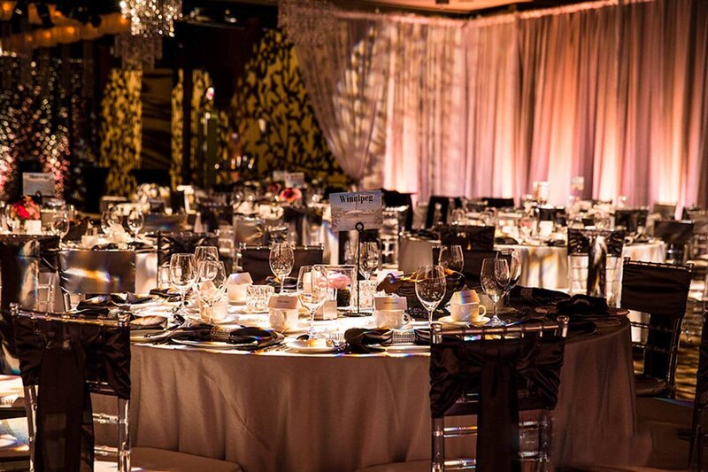 This elegant photograph captures a beautifully arranged wedding reception in the ballroom at Hotel Arts, highlighting the venue's sophisticated charm for an unforgettable celebration.
