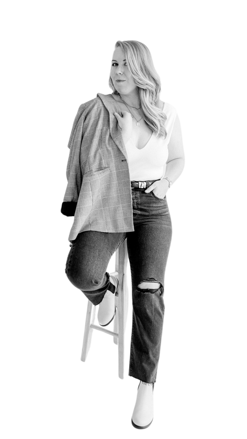 Lizzy Grant sitting on bar stool with blazer over shoulder