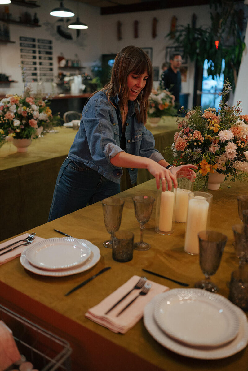 Boise wedding and event planner, Alex, sets candles on a table at a vows renewal she planned.