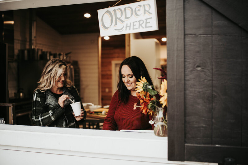 mother and daughter at coffee shop window during brand photography session in southern Alberta 
