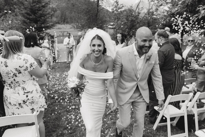 bride and groom petal toss walking back down the aisle at their fernie wedding