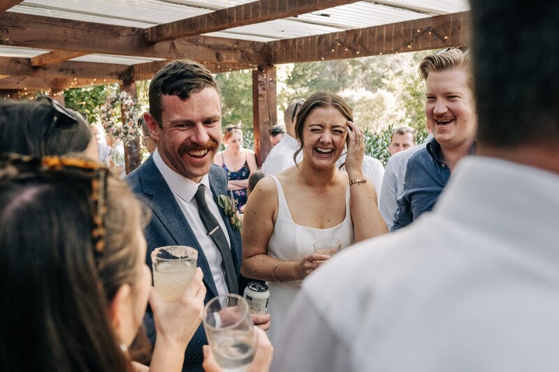 guests laugh with cocktails on the deck of reception area at mt vernon lodge