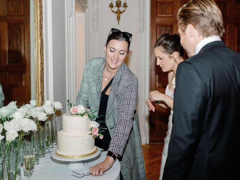 Wedding planner explains to bride and groom how to cut the cake
