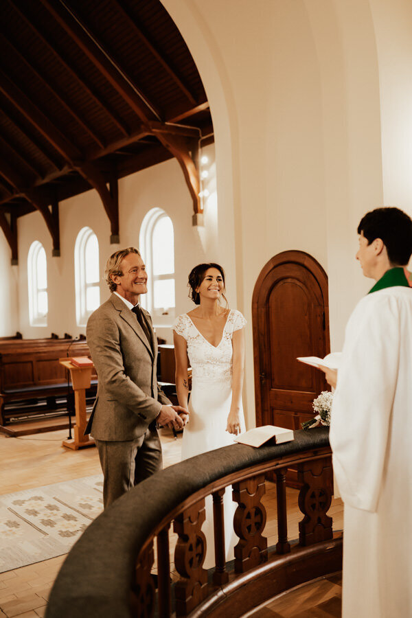 couple standing in church smiling during their ceremony in halmstad