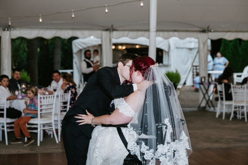 bride wearing a custom lace veil while hugging her groom