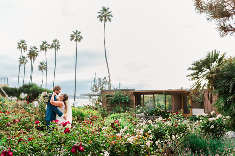 Bride and groom share an intimate moment in the gardens of their La Jolla Ca venue nearby the beaches