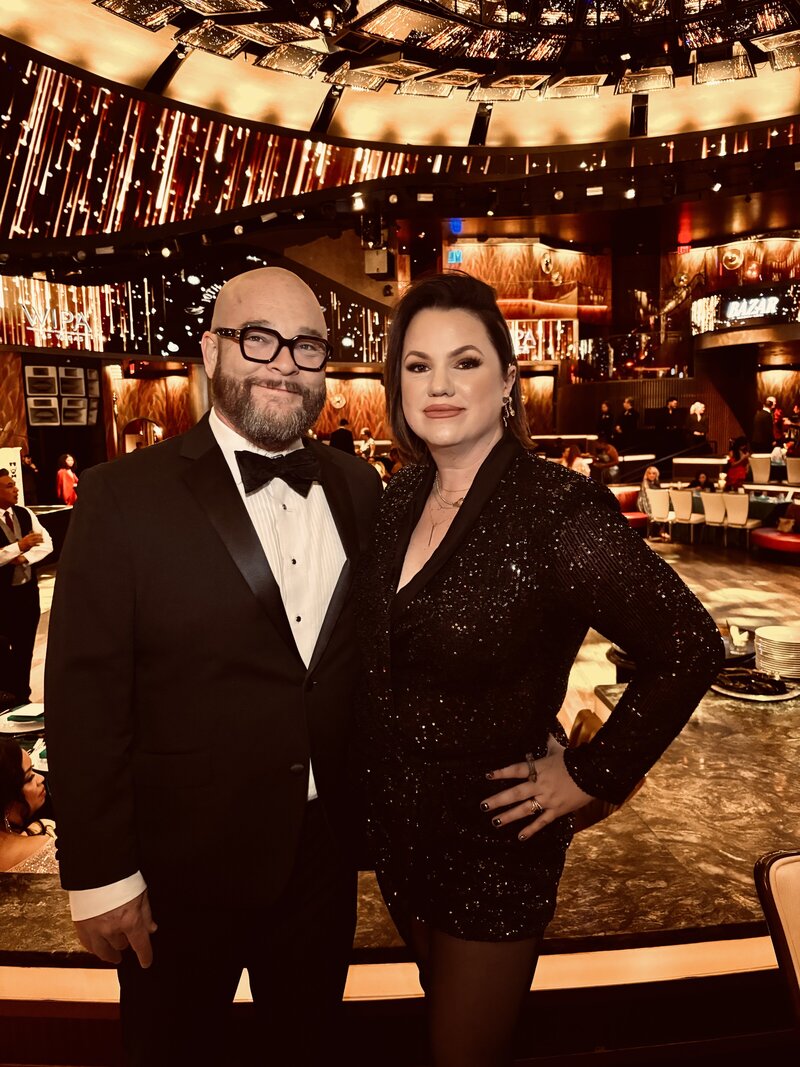 Two people holding hands and posing in front of the Double Down Saloon in Las Vegas, NV