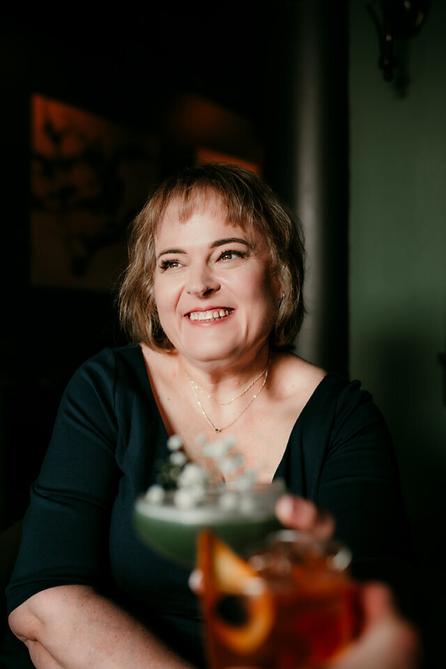 Confident woman smiling in cozy indoor setting during online dating photo session in Minneapolis