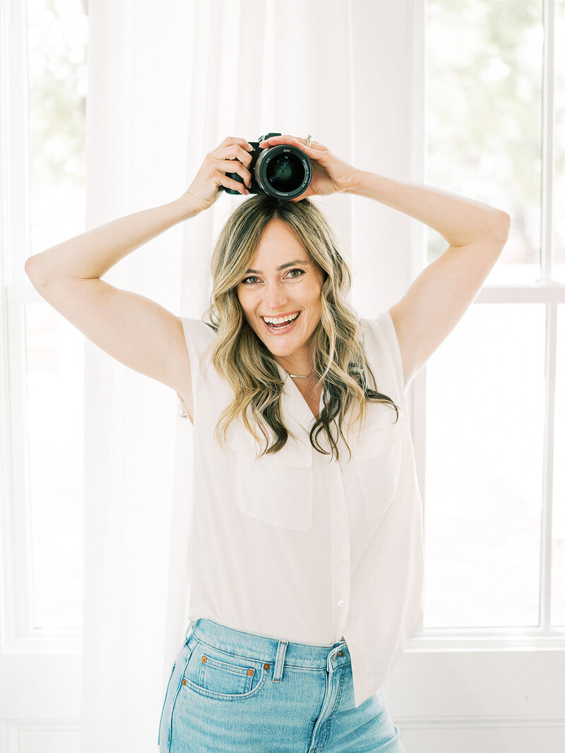 Teressa Jane a San Antonio Newborn Photographer holds a camera on her head