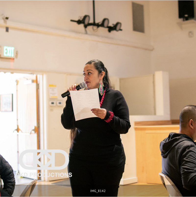Person reading poetry at an event on a mic