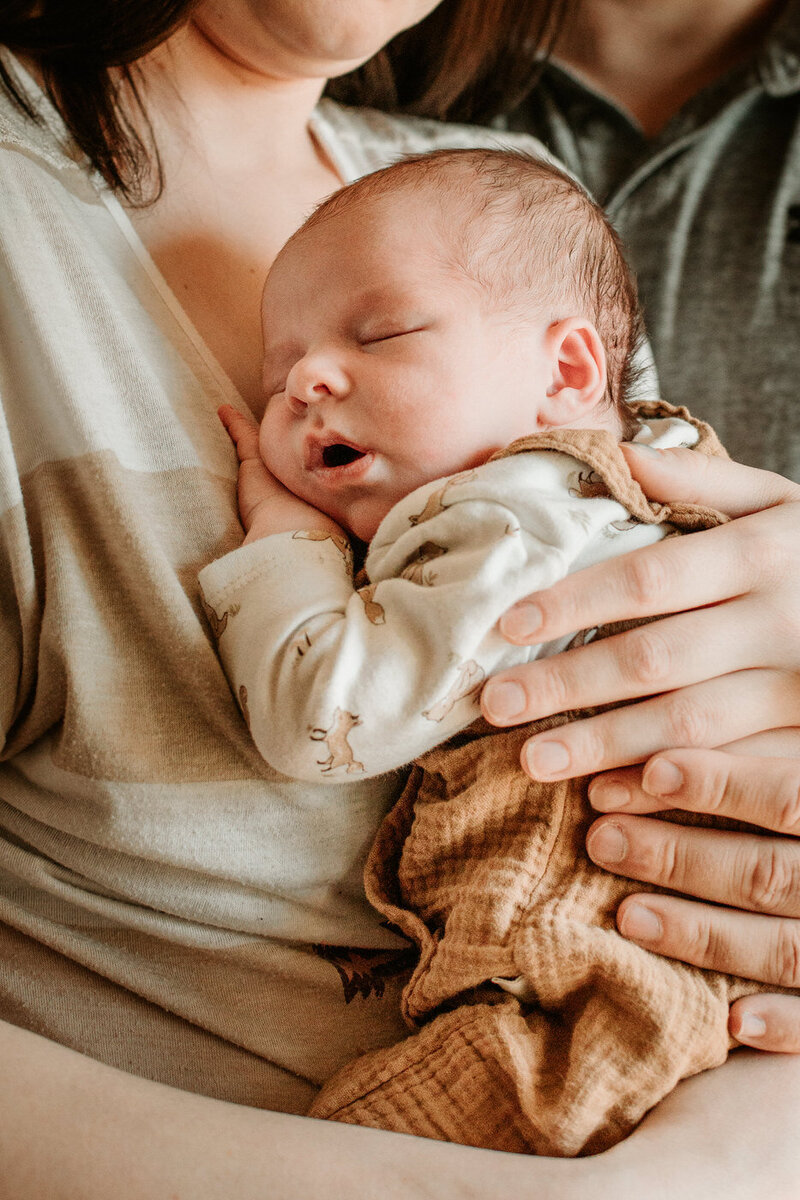 newborn in cream coloured outfit 