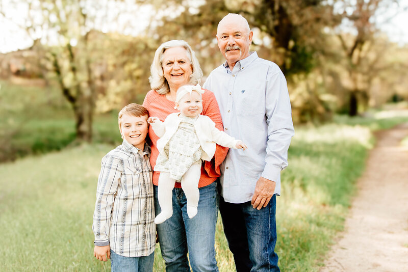 grandparents pose with their 2 grandchildren