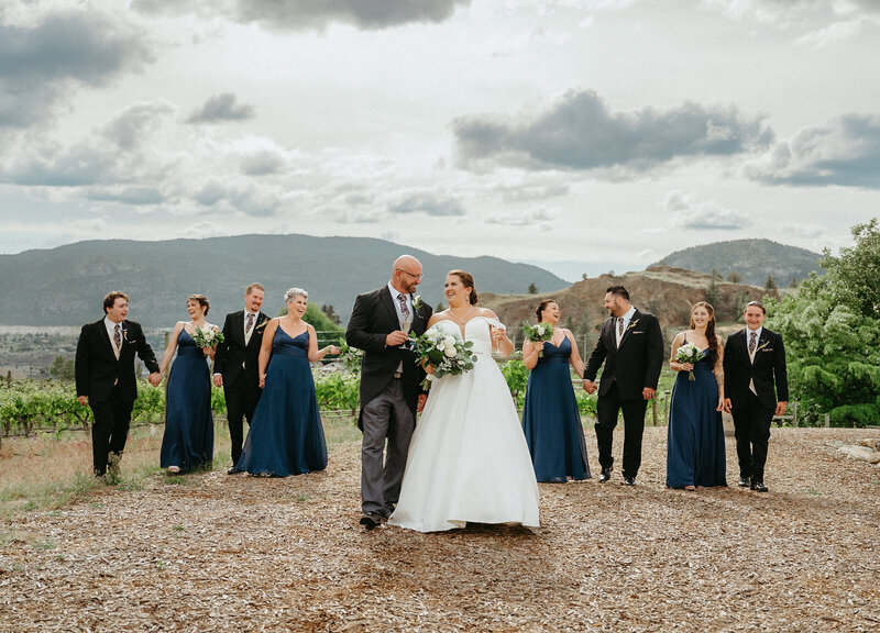 Romantic wedding portrait on top of a mountain in Penticton. the bride is wearing a long white wedding dress and the groom a gray suit