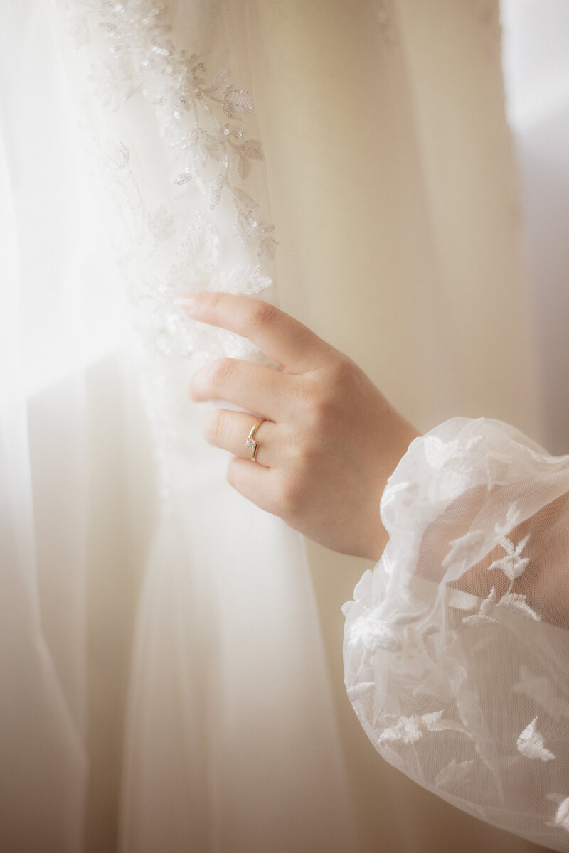 This image is of a bride touching her dress.