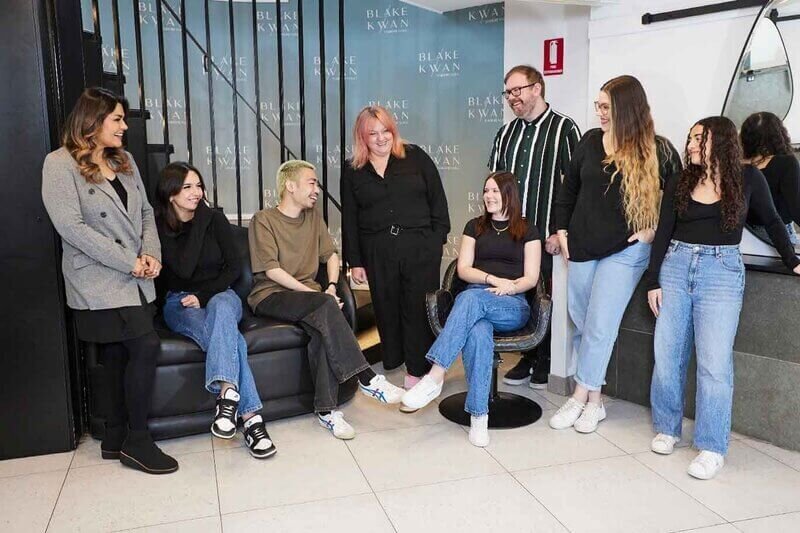 Blake & Kwan team in Cronulla, showcasing professional hair specialists in a stylish salon interior with staircase backdrop.