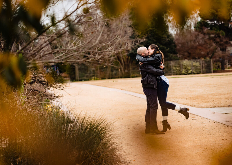Couple embraces and kisses at JC Raulston Arboretum in Raleigh, NC