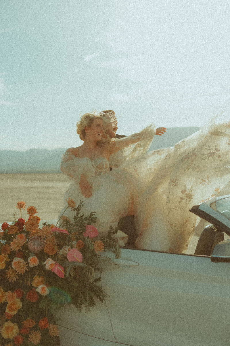 woman in convertible in wedding dress
