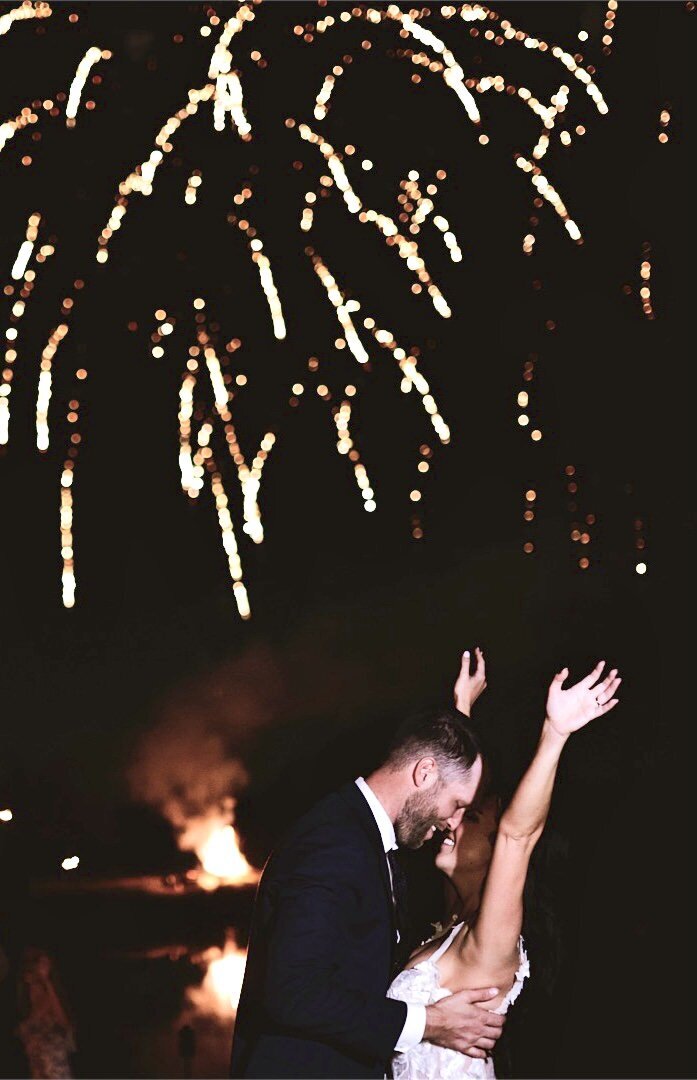 A Texas Wedding Videographer captures the emotional embrace of a bride and groom amid a breathtaking firework display.