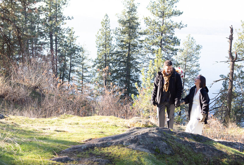 Bride and Groom hiking in warm jackets with wedding clothes