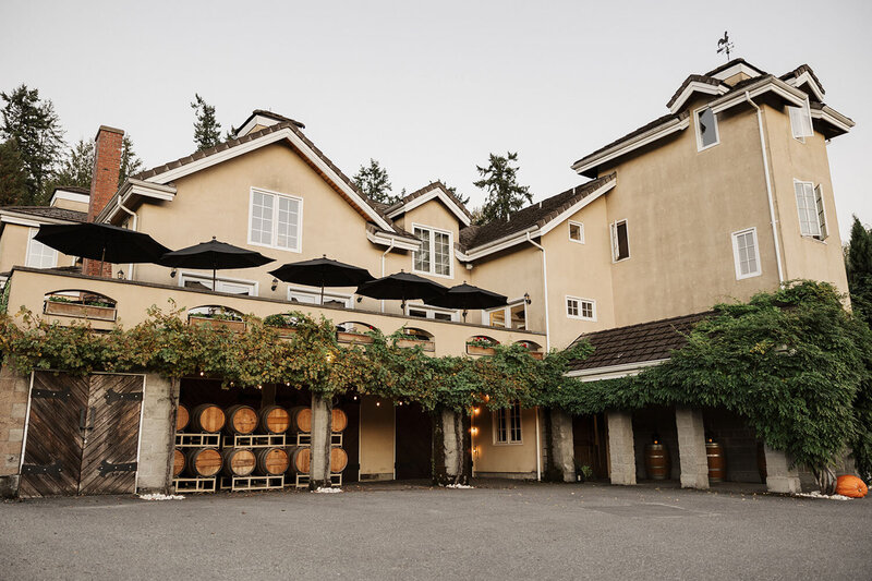 Exterior of the venue featuring barrel decor and terrace umbrellas