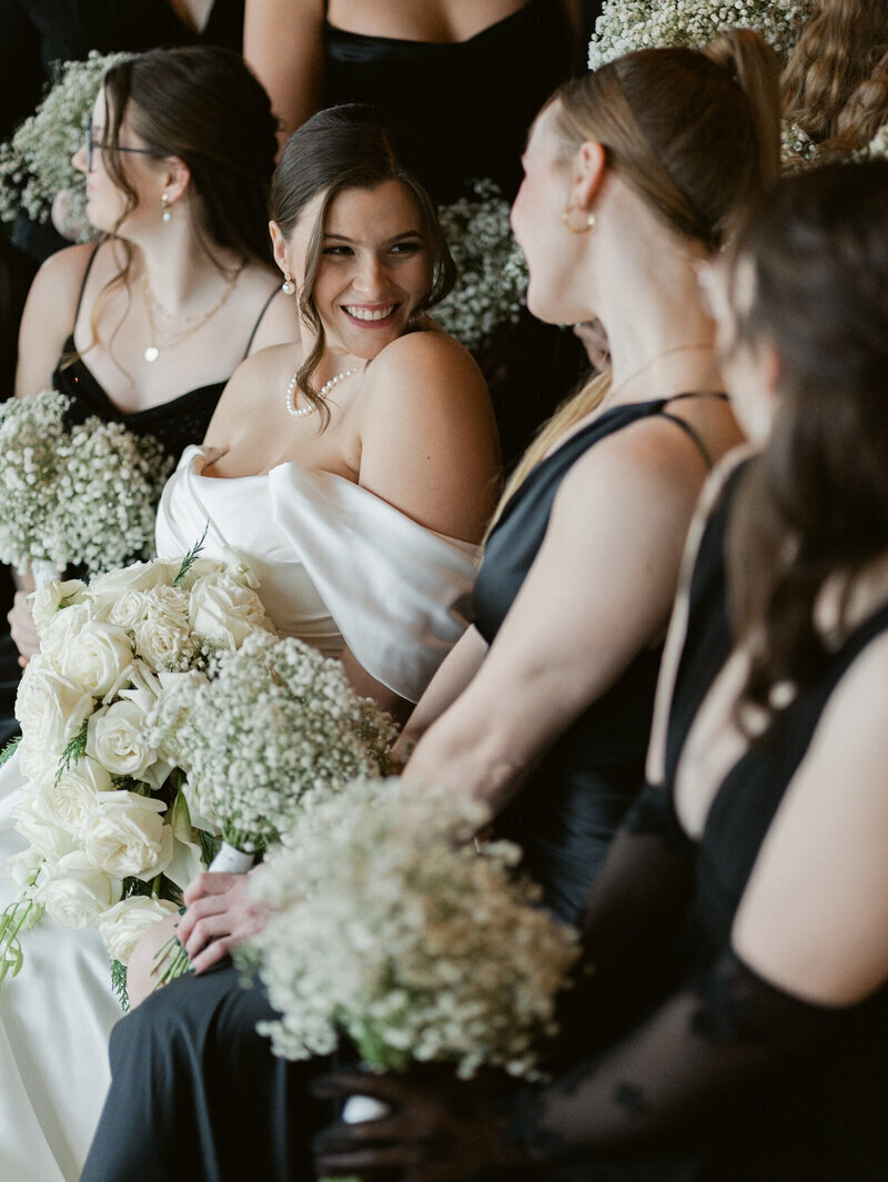bridesmaids holding flowers looking at bride, by dc film wedding photographer