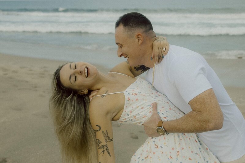 couple dances on beach for photo session